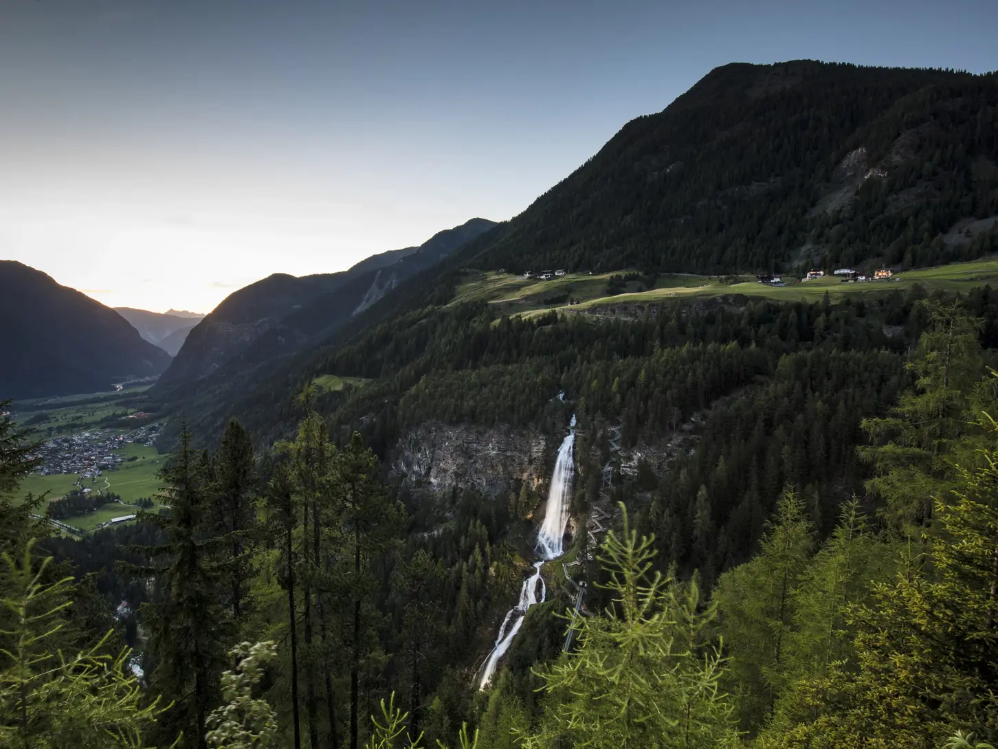 Der Stuibenfall zwischen bewaldeten Bergen bei Umhausen im Ötztal
